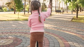 Peu Fille Apprend A Monter Un Scooter Bebe Heureux De Jouer Dans Le Parc L Enfant En Bonne Sante Monte Un Scooter Dans La Ville H Banque De Videos Video Du Loisirs