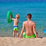 Peuterjongen op strand met vader stock afbeeldingen Peuterjongen op strand met vader stock afbeeldingen