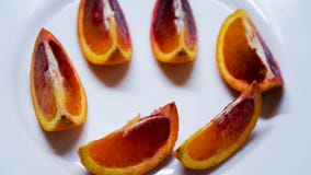 Pezzi di arancia sanguinella sul piatto bianco, vista superiore immagini stock libere da diritti Pezzi di arancia sanguinella sul piatto bianco, vista superiore immagini stock libere da diritti