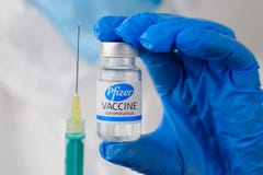 Pfizer vaccine and disposable syringe for injection in doctors hands. Prevention of coronavirus, Sars-cov-2, Covid-19