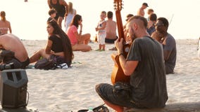Phangan, Thaïlande - 23 février 2019 Zen Beach Le jeune type de sourire joue la guitare sur une côte tropicale d'été de paradis à clips vidéos Phangan, Thaïlande - 23 février 2019 Zen Beach Le jeune type de sourire joue la guitare sur une côte tropicale d'été de paradis à clips vidéos