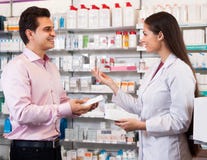 Pharmacienne et visiteuse de femme à la pharmacie photographie stock libre de droits Pharmacienne et visiteuse de femme à la pharmacie photographie stock libre de droits