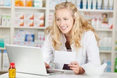 Pharmacist Holding Prescription While Using Laptop At Coun Stock Photography Pharmacist Holding Prescription While Using Laptop At Coun Stock Photography