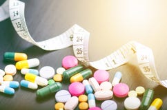 Pharmacy background on a black table with measuring tape. Tablets on a black background. Pills. Medicine and healthy. Close up of stock photography Pharmacy background on a black table with measuring tape. Tablets on a black background. Pills. Medicine and healthy. Close up of stock photography
