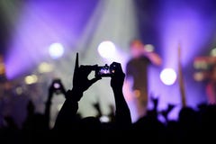 Phone video recording the performance of a rock band in the concert