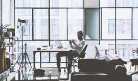 Photo bearded account manager working with new project oped space loft studio. Looking modern smartphone. Contemporary stock image Photo bearded account manager working with new project oped space loft studio. Looking modern smartphone. Contemporary stock image