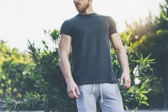 Photo Bearded Muscular Man Wearing Black Blank t-shirt and shorts in summer vacation. Relaxing time near the lake. Green. City Garden Park Sunset Background Royalty Free Stock Image Photo Bearded Muscular Man Wearing Black Blank t-shirt and shorts in summer vacation. Relaxing time near the lake. Green. City Garden Park Sunset Background Royalty Free Stock Image