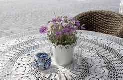 Photo of cozy cafe table on paving stone street in the sunny summer morning with beautiful flowers on lace tablecloth stock image Photo of cozy cafe table on paving stone street in the sunny summer morning with beautiful flowers on lace tablecloth stock image