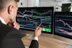 Photo d'homme d'affaires réussi se reposant à la table dans le bureau et travaillant avec des graphiques et des diagrammes sur l' photographie stock Photo d'homme d'affaires réussi se reposant à la table dans le bureau et travaillant avec des graphiques et des diagrammes sur l' photographie stock