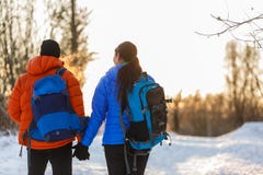 Photo de dos de l'homme et de femme avec des sacs à dos en hiver image libre de droits Photo de dos de l'homme et de femme avec des sacs à dos en hiver image libre de droits