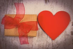 Photo de vintage, cadeau enveloppé pour le jour de valentines et coeur rouge sur la vieille table en bois Images stock Photo de vintage, cadeau enveloppé pour le jour de valentines et coeur rouge sur la vieille table en bois Images stock