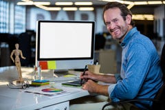 Photo editor smiling while working on graphics tablet royalty free stock images Photo editor smiling while working on graphics tablet royalty free stock images