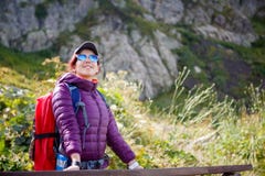 Photo of girl in sunglasses with backpack on background of mountains