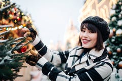 Photo of happy woman near painted Christmas tree on street royalty free stock images Photo of happy woman near painted Christmas tree on street royalty free stock images
