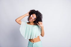 Photo Portrait Of Cheerful Mulatto Brunette Girl Curly Hair In Sunglass Dancing In Summer Clothes Isolated On Grey Color Stock Photo Photo Portrait Of Cheerful Mulatto Brunette Girl Curly Hair In Sunglass Dancing In Summer Clothes Isolated On Grey Color Stock Photo