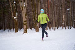 Photo of sportswoman running in winter forest