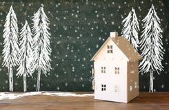Photo of toy house in front of chalkboard with winter concept drawings stock photography Photo of toy house in front of chalkboard with winter concept drawings stock photography