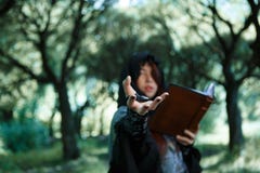 Photo of witch with outstretched hand and book