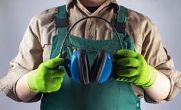 Worker in green overall outfit with headphones royalty free stock photography Worker in green overall outfit with headphones royalty free stock photography