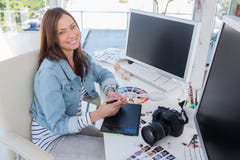 Photographe éditeur gai fonctionnant avec un comprimé graphique photographie stock Photographe éditeur gai fonctionnant avec un comprimé graphique photographie stock