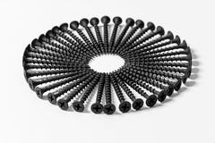 Wonderful circle of black screws, set one by one, on a white background royalty free stock photos Wonderful circle of black screws, set one by one, on a white background royalty free stock photos