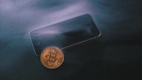 A physical Bitcoin on a smartphone`s screen on black background stock video A physical Bitcoin on a smartphone`s screen on black background stock video