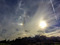 Phénomène de chien de Sun près de coucher du soleil dans les nuages et le courant de jet au-dessus de St George Neighborhood photo stock Phénomène de chien de Sun près de coucher du soleil dans les nuages et le courant de jet au-dessus de St George Neighborhood photo stock