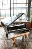 Piano de cauda e tamborete pretos em uma sala bem iluminado imagens de stock Piano de cauda e tamborete pretos em uma sala bem iluminado imagens de stock