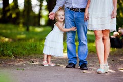 Piccola ragazza bionda molto sveglia che tiene la mamma ed il papà del piede fotografie stock Piccola ragazza bionda molto sveglia che tiene la mamma ed il papà del piede fotografie stock