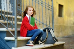 Piccola scolara adorabile che studia all'aperto il giorno luminoso di autunno Giovane studente che fa il suo compito Istruzione p immagini stock libere da diritti Piccola scolara adorabile che studia all'aperto il giorno luminoso di autunno Giovane studente che fa il suo compito Istruzione p immagini stock libere da diritti