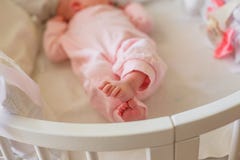 Piccoli piedi del bambino placcati in pagliaccetto rosa Dita minuscole del neonato Il bambino ha attraversato le gambe e le bugie immagini stock Piccoli piedi del bambino placcati in pagliaccetto rosa Dita minuscole del neonato Il bambino ha attraversato le gambe e le bugie immagini stock