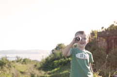 Piccolo bambino che gioca pirata, esaminante cannocchiale fatto da cardb Fotografia Stock Libera da Diritti Piccolo bambino che gioca pirata, esaminante cannocchiale fatto da cardb Fotografia Stock Libera da Diritti