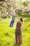 Piccolo bambino sulle mani della madre donna che gioca con il bambino fuori fotografia stock Piccolo bambino sulle mani della madre donna che gioca con il bambino fuori fotografia stock
