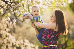 Piccolo bambino sulle mani della madre donna che gioca con il bambino fuori fotografia stock Piccolo bambino sulle mani della madre donna che gioca con il bambino fuori fotografia stock