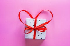 Piccolo contenitore di regalo elegante legato con il nastro rosso con l'arco nella forma del cuore su fondo rosa Valentine Greeti Immagine Stock Libera da Diritti Piccolo contenitore di regalo elegante legato con il nastro rosso con l'arco nella forma del cuore su fondo rosa Valentine Greeti Immagine Stock Libera da Diritti