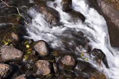 Piccolo fiume della montagna che circola sull'esposizione lunga delle rocce fotografia stock libera da diritti Piccolo fiume della montagna che circola sull'esposizione lunga delle rocce fotografia stock libera da diritti