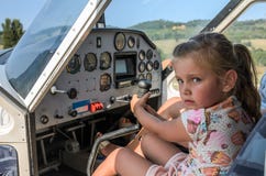 Piccolo pilota bambino della ragazza adorabile al volante di un aereo leggero fotografia stock libera da diritti Piccolo pilota bambino della ragazza adorabile al volante di un aereo leggero fotografia stock libera da diritti