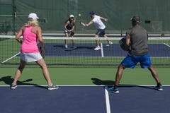Pickleball - action de doubles mélangés image stock Pickleball - action de doubles mélangés image stock