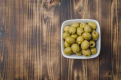 Pickled Green Olives In A Bowl On A Wooden Background. Top View, Copyspace. Olives Background Stock Photo