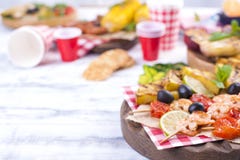 Picknick med grillad mat Korvar och havre på grillfest, räka, grönsaker och frukter Läcker sommarlunch- och plast-disk arkivfoto Picknick med grillad mat Korvar och havre på grillfest, räka, grönsaker och frukter Läcker sommarlunch- och plast-disk arkivfoto