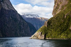 Picos cobertos de neve de Milford Sound Mountainin na água foto de stock Picos cobertos de neve de Milford Sound Mountainin na água foto de stock