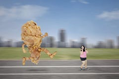 Asian obese woman chased by a fried chicken royalty free stock photo Asian obese woman chased by a fried chicken royalty free stock photo