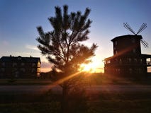 A picturesque sunset against a blue sky, houses and a mill stock photos A picturesque sunset against a blue sky, houses and a mill stock photos