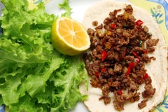 Piec minced wołowinę z chili pieprzem na tortilla z sałatą i cytryną fotografia stock Piec minced wołowinę z chili pieprzem na tortilla z sałatą i cytryną fotografia stock