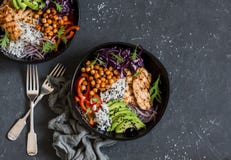 Piec na grillu kurczak, ryż, korzenni chickpeas, avocado, kapusta, pieprzowy Buddha puchar na ciemnym tle, odgórny widok obraz stock Piec na grillu kurczak, ryż, korzenni chickpeas, avocado, kapusta, pieprzowy Buddha puchar na ciemnym tle, odgórny widok obraz stock