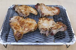Piec na grillu siatkę i kawałki piec wieprzowina kotleciki na nim zdjęcie royalty free Piec na grillu siatkę i kawałki piec wieprzowina kotleciki na nim zdjęcie royalty free
