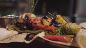 Piec na grillu łosoś ryba słuzyć z ziele, oliwkami, chili pieprzem i cytryny lying on the beach na pita zamkniętym w górę, Narząd zdjęcie wideo Piec na grillu łosoś ryba słuzyć z ziele, oliwkami, chili pieprzem i cytryny lying on the beach na pita zamkniętym w górę, Narząd zdjęcie wideo