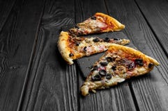 Pieces of pizza on dark black board, traditional italian pizza royalty free stock photography Pieces of pizza on dark black board, traditional italian pizza royalty free stock photography