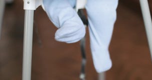 Piedi di un neonato in una sedia Piedi di un neonato in una sedia
