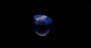 Piedra preciosa del lapislázuli que gira la superficie negra Piedra preciosa del lapislázuli que gira la superficie negra
